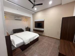 a bedroom with a bed and a flat screen tv at Hotel Pratap Palace in Bharatpur +16 photos