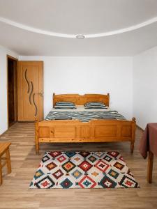 a bedroom with a bed and a rug on the floor at PENSIUNEA BOCA VORONET in Voronet