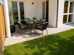 a table and chairs on a patio with grass at Schongau Suites Premium Apartments XL in Schongau