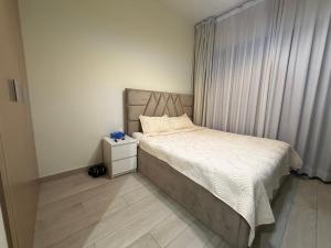 a small bedroom with a bed and a window at Azizi Riviera in Dubai