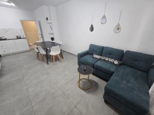 a living room with a blue couch and a table at Convince in Larnaca