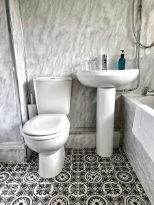 a bathroom with a white toilet and a sink at The Alexandria in Westhoughton