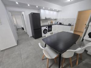 a kitchen with a black table and white chairs at Convince in Larnaca