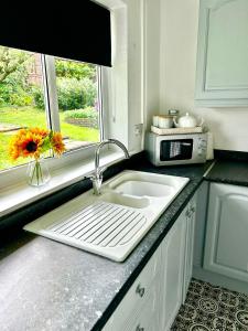 a kitchen counter with a sink and a microwave at The Alexandria in Westhoughton +6 photos