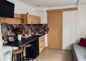 a kitchen with a black counter and wooden cabinets at Wypoczynek u Piotra z jacuzzi in Susiec