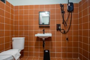 a bathroom with a toilet and a sink and a mirror at Judy house Betong in Betong