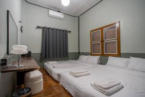 a bedroom with a large white bed with towels on it at Judy house Betong in Betong