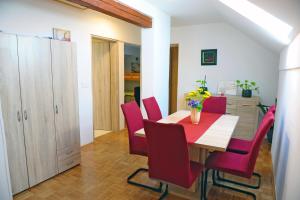 a dining room with a table and red chairs at Green Touch in Ivanjkovci