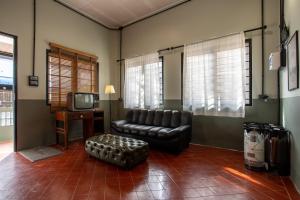 a living room with a leather couch and a tv at Judy house Betong in Betong