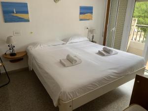 a large white bed with two white towels on it at Apartment Sunset Moraira City in Moraira +30 photos