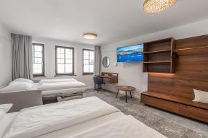 a hotel room with two beds and a tv at Hotel Mondschein in Innsbruck