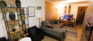 a living room with a couch and a tv at Sesimbra Sea Apartment with Pool & Gym near Lisbon in Sesimbra