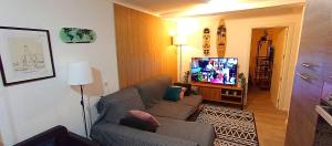 a living room with a couch and a flat screen tv at Sesimbra Sea Apartment with Pool & Gym near Lisbon in Sesimbra +56 photos