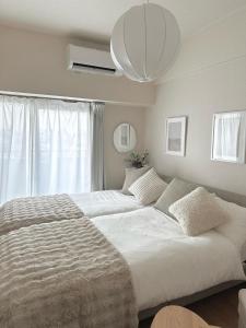 a bedroom with two beds and a large window at Miroku Nagoya in Minami-sotoborichō +23 photos