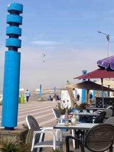 eine Gruppe von Tischen und Stühlen neben dem Strand in der Unterkunft Dar DADA-Aglou in Tiznit