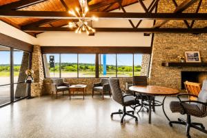 a living room with a fireplace and tables and chairs at Segovia Lodge Junction TX I -10 in Junction