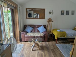 a living room with a couch and a mirror at Sunnyside Annexe in Oxford