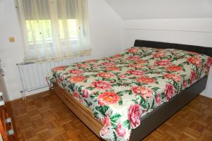 a bed with a floral comforter on it in a bedroom at Green Touch in Ivanjkovci