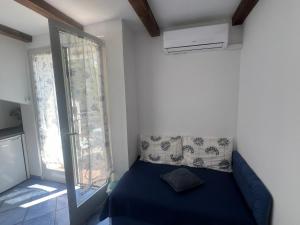 a bedroom with a blue bed and a window at Apartments Tajana in Novigrad Istria