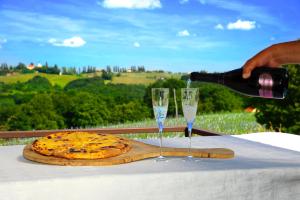 a person pouring a glass of wine next to a pizza at Green Touch in Ivanjkovci +5 photos