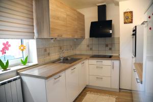 a kitchen with white cabinets and a sink at Green Touch in Ivanjkovci