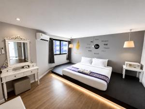 a bedroom with a large bed and a mirror at Sawasdee Siam Pattaya Hotel in Pattaya