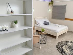 a bedroom with white shelves and a bed in a room at בקתות לוטן דלתון - 4 בקתות עם ג'קוזי פרטי ו-2 בריכות משותפות in Shahar +28 photos