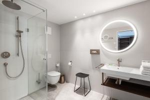 a bathroom with a shower and a toilet and a sink at Hotel Mondschein in Innsbruck