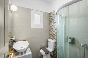 a bathroom with a toilet and a sink and a shower at Salty Wind Antiparos Apartments and Studios in Agios Georgios +88 photos