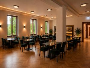 ein Restaurant mit Tischen und Stühlen in einem Raum in der Unterkunft Pawlow History Hotel in Wolkenstein