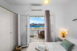 a bedroom with a bed and a view of the ocean at Salty Wind Antiparos Apartments and Studios in Agios Georgios