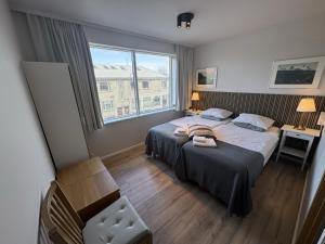 a bedroom with a large bed and a window at Downtown Reykjavík Apartments in Reykjavík