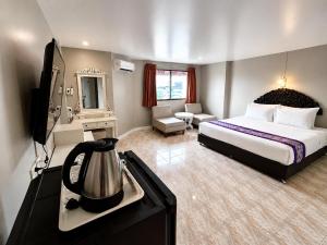 a hotel room with a bed and a television at Sawasdee Siam Pattaya Hotel in Pattaya