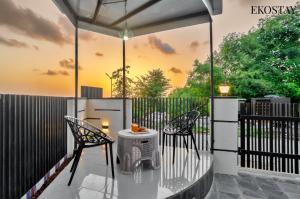 a patio with two chairs and a table and a fence at EKOSTAY - ONYX Villa in Mumbai