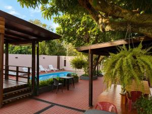 a patio with a table and chairs next to a pool at Hostel & Posada Noelia in Puerto Iguazú +10 photos