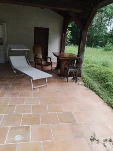 a patio with a bench and a table and chairs at Maison indépendante studio calme et confort in Ervauville