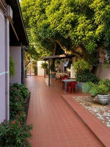 a patio with a red brick walkway with a table at Hostel & Posada Noelia in Puerto Iguazú