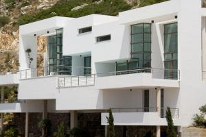 a white building with balconies in front of a mountain at Altea Hills Luxury Villas in Altea
