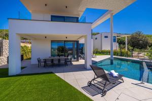 a villa with a swimming pool and a patio at Luxury villa 45 with infinity pool in Punat