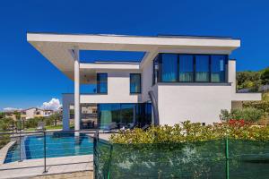 a house with a swimming pool in front of it at Luxury villa 45 with infinity pool in Punat