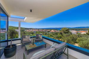 a balcony with couches and a table with a view at Luxury villa 45 with infinity pool in Punat +33 photos