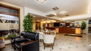 a restaurant with a table and chairs and a bar at Hotel Boss in Žilina