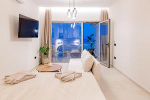 a white living room with a couch and a table at Blue Horizon Studios in Laganas