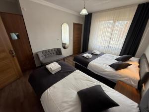 a hotel room with two beds and a chair at Kütahya Şehir Otel in Kütahya