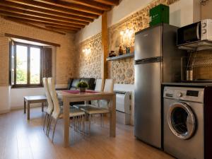 a kitchen and dining room with a table and a refrigerator at Capricho Toledano, Apartamento con terraza en el centro histórico in Toledo +13 photos