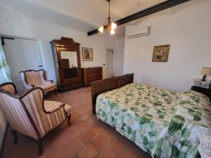 a bedroom with a bed and two chairs in it at B&B Anima Selvaggia Ranch in Castellero