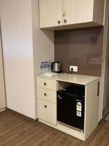 a small kitchen with a stove and a microwave at Weekend Address By Honest Homes in Surat