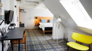a bedroom with a bed and a desk and chairs at Ibsens Hotel in Copenhagen