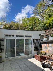 a house with sliding glass doors and a patio at The Welcome Haven - Cozy Studio with Patio & Free Parking in Chislehurst +3 photos