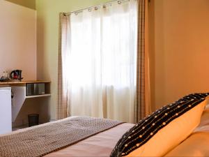 a bedroom with a bed with a curtain and a window at Kruger Foothills Lodge - Near Kruger National Park in Hoedspruit